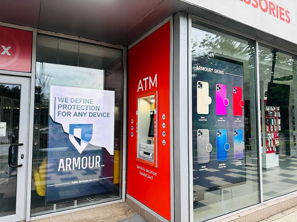 Vitrina laterală iFix cu panoul „We define protection for any device” și expunerea Armour® Skins — Timișoara